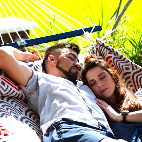 Couple laying in the sun on the 55-inch Red and Grey Quilted Hammock.
