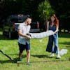 Couple holding a raveled up Bliss Hammocks 55-inch Blue Geo Diamond Quilted Hammock.