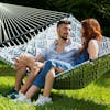 Couple sitting outside on the Bliss Hammocks 55-inch Blue Geo Diamond Quilted Hammock.