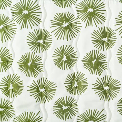 Close-up of the fabric and pattern, showing the white color white a green burst pattern.