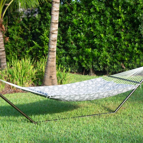 55-inch Hexagonal Quilted Hammock secured to a stand on grass.