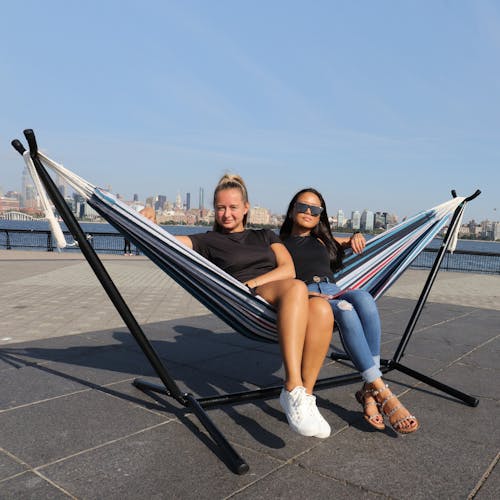 2 girls sitting in the 60-inch America's Cup Hammock and Stand.