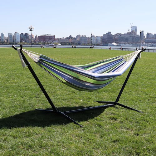 60-inch garden stripe hammock and stand on grass with the New York skyline in the background.