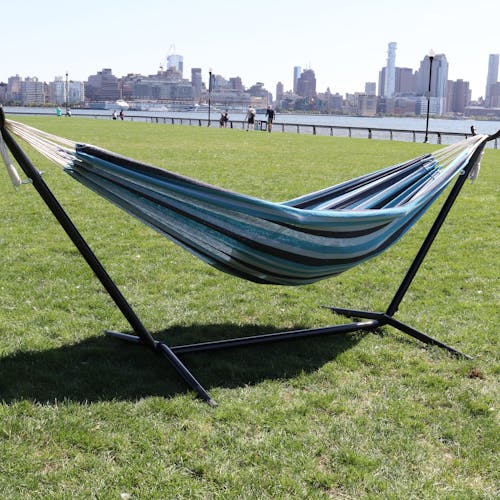 60-inch Nautical stripe hammock and stand on grass with the New York skyline in the background.