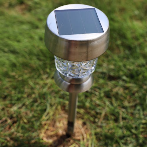 Top-angled view of the 14-inch Solar LED Pathway Light staked in the ground, showing the solar panel on top.