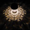 Light turned on, creating a triangle light pattern on the ground around it.