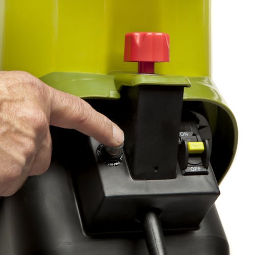 Person with their finger on the circuit overload reset button on the Sun Joe 14-amp electric wood chipper.