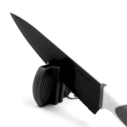 Black chef's knife with the blade in the sharpener.