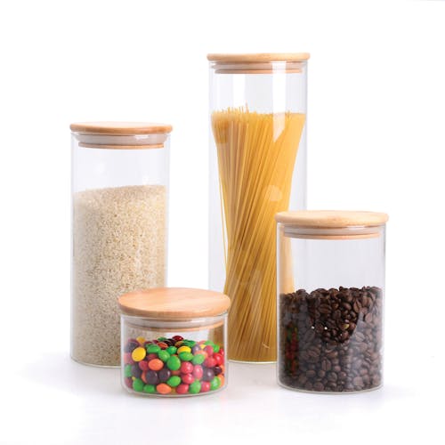 EatNeat Set of 4 Airtight Glass Kitchen Containers with bamboo lids filled with different foods.