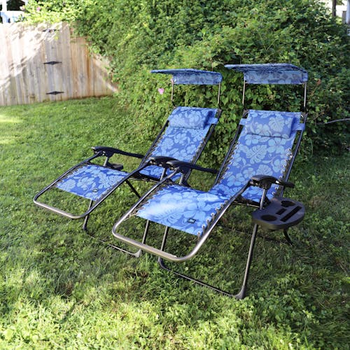 Set of 2 26-inch Blue Flower Zero Gravity Chairs reclined on a lawn.