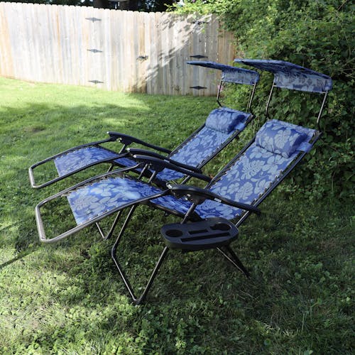 Side view of 2 reclined 26-inch Blue Flowers Zero Gravity Chairs on a lawn.