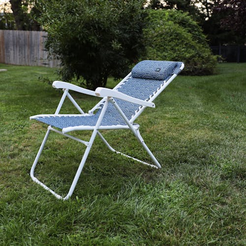 Angled view of a reclined 26-inch Blue Scallop Reclining Sling Chair on a lawn.