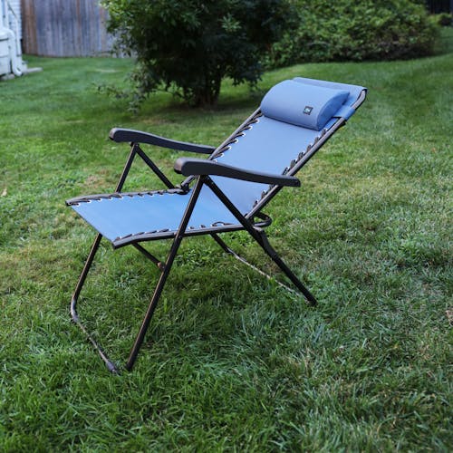 Angled view of a reclined 26-inch Denim Blue Reclining Sling Chair on a lawn.