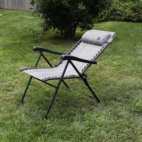 Angled view of a reclined 26-inch Platinum Reclining Sling Chair on a lawn.
