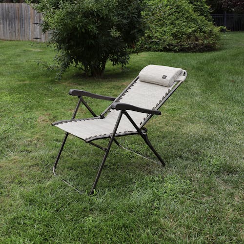 Angled view of a reclined 26-inch Sand Reclining Sling Chair on a lawn.