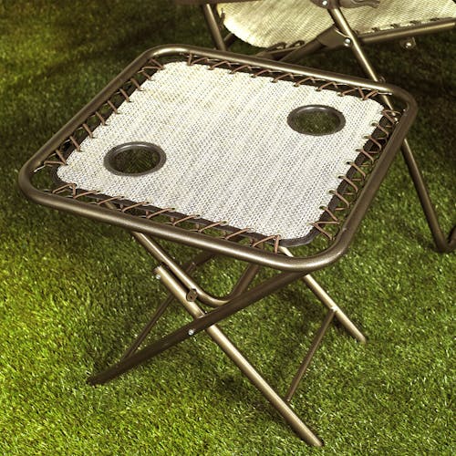20-inch sand folding sand side table on grass.