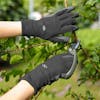 Sun Joe 3-pack of Nitrile-Palm Reusable Black Gloves being used while cutting a branch with pruners.