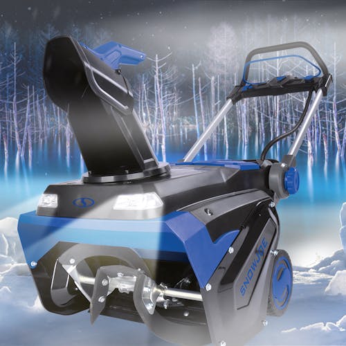 Snow Joe 100-volt 21-inch Cordless Brushless Variable Speed Single Stage Snow Blower Kit in the snow at night with the headlights on.