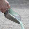 Snow Joe Premium Enviro Blend Ice Melter being poured form the scooper.