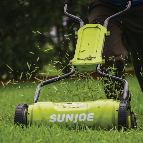 Close-up of the Sun Joe 18-inch Silent Push Reel Lawn Mower cutting grass.