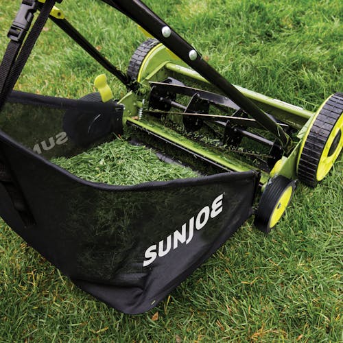 Sun Joe 18-inch manual reel mower with grass catcher filled with grass.