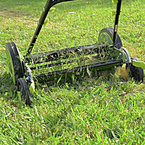 Sun Joe 16-inch manual reel lawn mower cutting grass.
