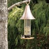 Martha Stewart Copper Bird Feeder with 4 ports hanging from a tree half-filled with bird seed.