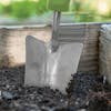 Close-up of the Martha Stewart Stainless Steel Transplanter dug in soil.