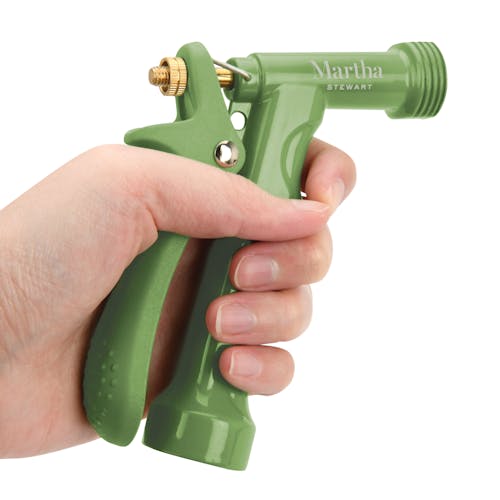 Person squeezing the lever on the Martha Stewart Metal Hose Nozzle.