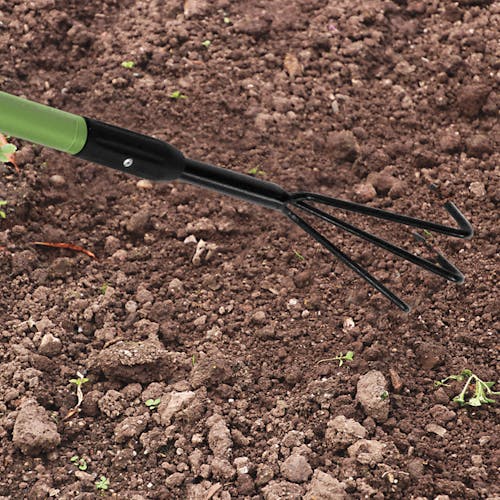 Martha Stewart Telescoping 3-Prong Garden Cultivator clawing through soil.