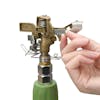 Person adjusting the coverage on the Martha Stewart Brass Impulse Tripod Sprinkler.