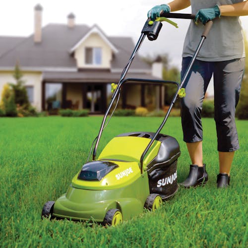 Person cutting a front lawn with the Sun Joe 24-Volt Cordless 14-inch Lawn Mower.