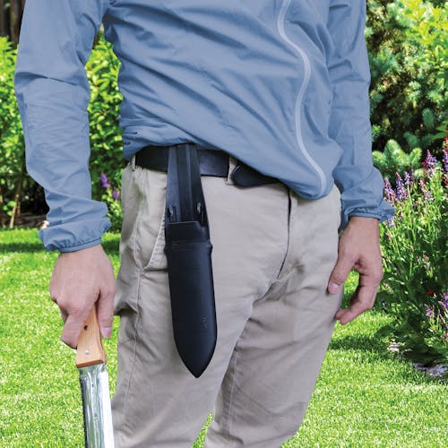 Person holding the Nisaku Hori-Hori Namibagata 7.25-inch Japanese Stainless Steel Weeding Knife with the sheath hanging from their belt.