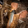Person using the Nisaku Limited Edition Mizukatana 7.5-Inch Japanese Stainless Steel Knife to peel the bark off a log.