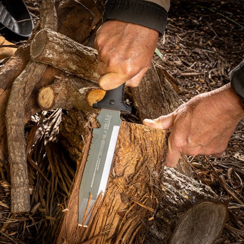 Person using the Nisaku Limited Edition Mizukatana 7.5-Inch Japanese Stainless Steel Knife to peel the bark off a log.