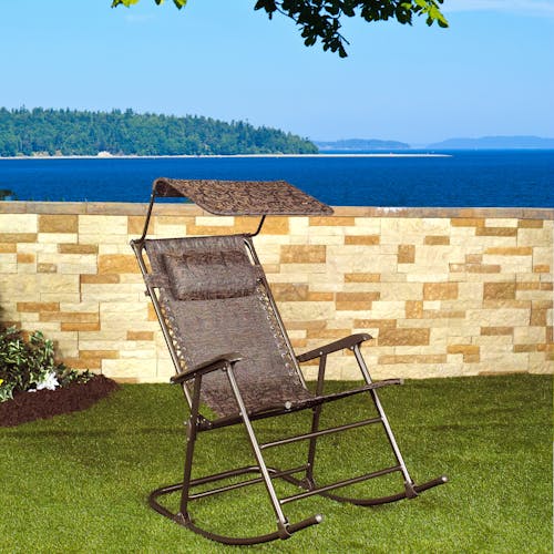 27-inch Brown Jacquard Rocking Chair on a lawn with the ocean in the background.