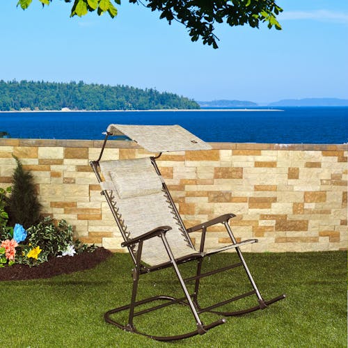 27-inch Sand Rocking Chair on a lawn with the ocean in the backgorund.