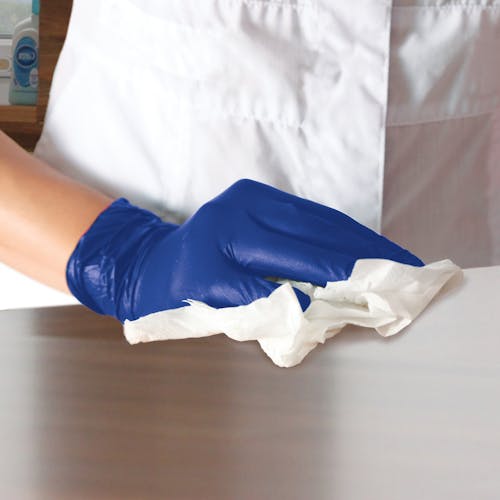 Person wearing blue Nitrile Disposable Gloves while cleaning.