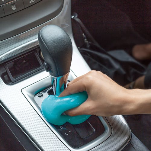 Auto Joe Reusable Multi-Purpose Cleaning Gel being used to clean the area around the gear shift.