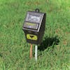 Sun Joe 3-in-1 Soil Meter with Moisture, pH, and Light Meter stuck into a lawn.