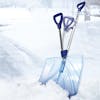 Snow Joe 18-inch Strain-Reducing Shatter Resistant Polycarbonate Snow Shovel wedged in snow with motion blur showing the spring assisted handle.