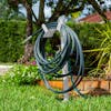 Aqua Joe White Garden Hose Stand with Brass Faucet placed in a lawn holding a hose.