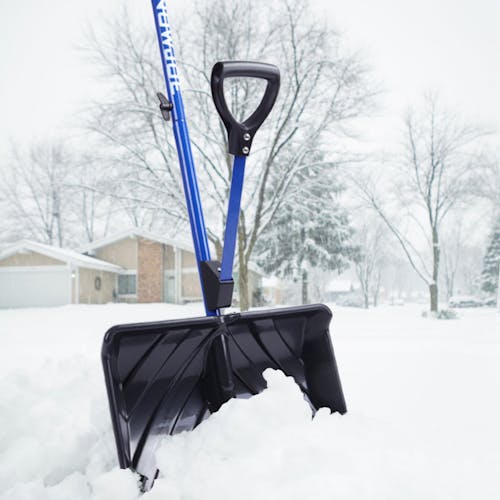 Snow Joe 18-inch Blue Shovelution Strain-Reducing Snow Shovel with spring assisted handle outside wedged in a snow pile.