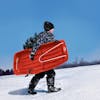 Kid carrying the Snow Joe 34-inch red-colored kids snow sled.