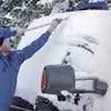 Snow Joe 4-in-1 telescoping blue-colored snow broom and ice scraper pushing snow off the top of a car.