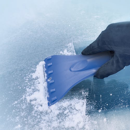 Snow Joe 4-in-1 telescoping blue-colored snow broom and ice scraper scraping ice off a window.