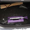 Snow Joe 19-inch 2-In-1 Telescoping purple Snow Broom and Ice Scraper compacted and stored in the trunk of a car.