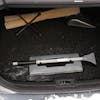 Snow Joe 19-inch 2-In-1 Telescoping gray Snow Broom and Ice Scraper compacted and stored in a car trunk.