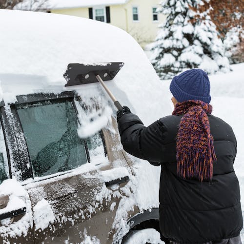 Person using SJBLZD-LED-BLK snow broom to remove snow from their vehicle roof