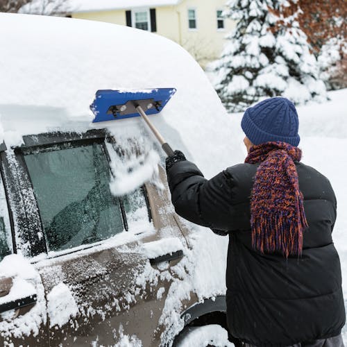Person using SJBLZD-LED lighted snow broom to clear off their car